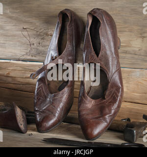 Older women's shoes and repair tools on the wooden table, close-up Stock Photo