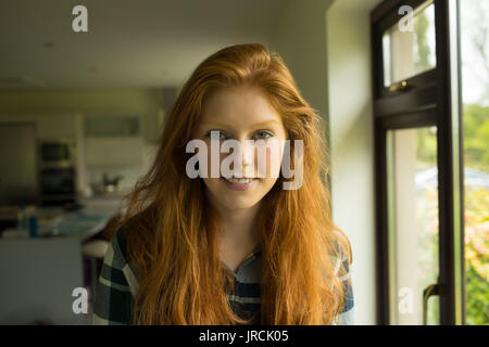 Portrait of smiling young woman by window at home Stock Photo