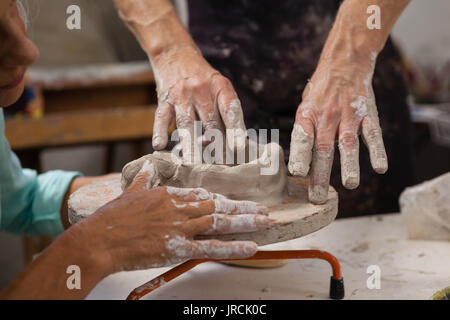 Attentive senior man molding clay in drawing class Stock Photo - Alamy