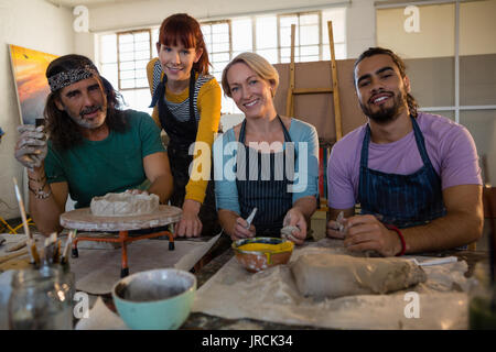 Portrait of adult students with teacher at table in art class Stock Photo