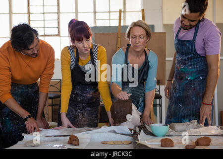 Teacher showing sculpture to adult student in art class Stock Photo