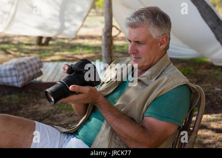 Mature man looking into camera outside tent Stock Photo