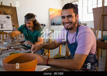 Portrait of smiling man sitting by teacher in art class Stock Photo
