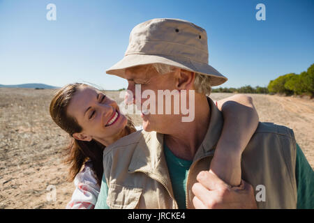 Smiling woman looking at mature man on landscape Stock Photo