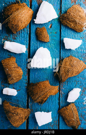 Top view of coconut flesh and hard coconut over a rusty blue background Stock Photo