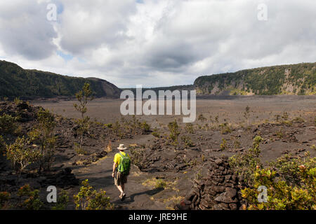 HI00371-00...HAWAI'I - Hiker crossing the Kilauea Iki Crater in Hawai'i Volcanoes National Park. (MR# V2) Stock Photo