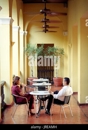 A couple enjoys a glass of wine at the El Picoteo restaurant located inside the El Convento hotel. An architectural landmark in the heart of historic  Stock Photo