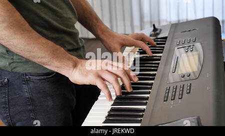 Man playing electric piano or electronic keyboard Stock Photo