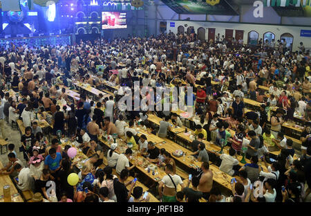 Qingdao. 5th Aug, 2017. People attend the Qingdao International Beer Festival in Qingdao, east China's Shandong Province, Aug. 4. 2017. The 27th Qingdao International Beer Festival kicked off here on Friday. Over 40 top international brands bringing more than 200 different beers took part in the festival. Credit: Zhu Zheng/Xinhua/Alamy Live News Stock Photo