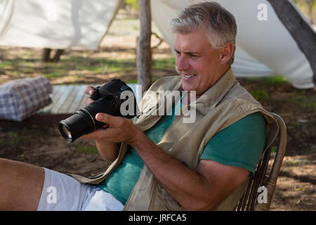 Man looking into camera outside tent Stock Photo