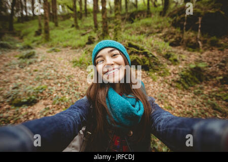 Portrait of smiling woman hiking in forest Stock Photo