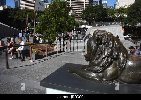 Brisbane, Australia: Office workers enjoy lunch in the sunshine watched over by one of the bronze lions of King George Square. Stock Photo