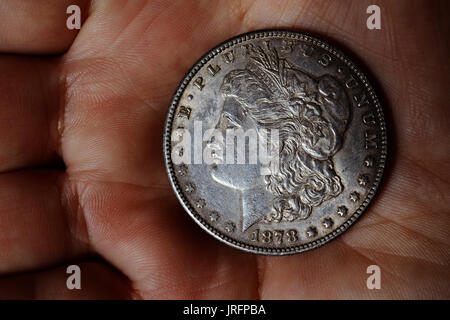 the old silver American dollar of 1878 in hand Stock Photo