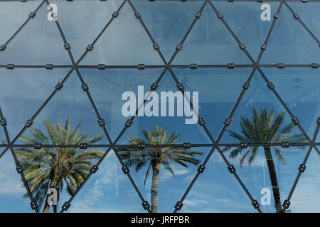 Triangular windows reflecting three palm trees at a museum in Florida, USA Stock Photo
