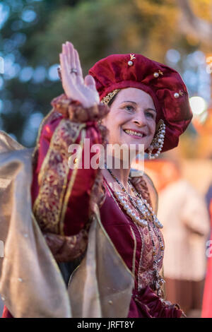 The Queen of a Renaissance Festival in southern France waves to her admirers while dressed in an elaborate costume of the era including jewels & gown. Stock Photo