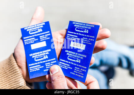 Perce, Canada - June 6, 2017: Closeup of tickets in tourist man's hand for boat trip to Rocher Perce rock and Bonaventure island in Gaspe Peninsula, Q Stock Photo