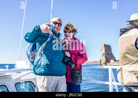 Perce, Canada - June 6, 2017: Couple taking selfie picture on boat by Rocher Perce rock in Gaspe Peninsula, Quebec, Gaspesie region Stock Photo