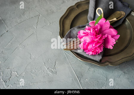 Summer table setting with bright peonies on dark rustic table with copyspace Stock Photo