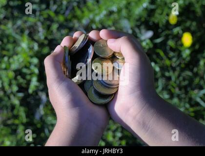 Two hands full of money. Kid's hands are full of Australian money Stock Photo