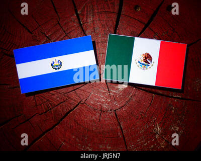 El Salvadoran flag with Mexican flag on a tree stump isolated Stock Photo