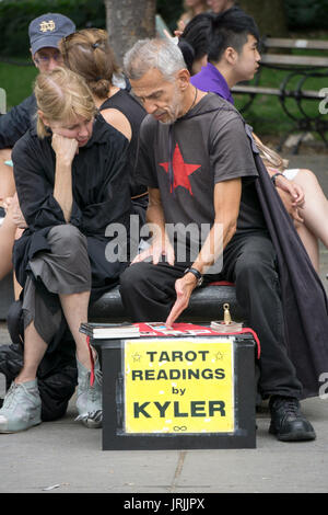 A tarot card reader doing a reading in Washington Square Park in Greenwich Village in New York City.