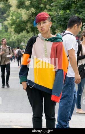 A young man with colorful hair and a colorful sweatshirt standing on a corner in downtown Manhattan, New York City, Stock Photo
