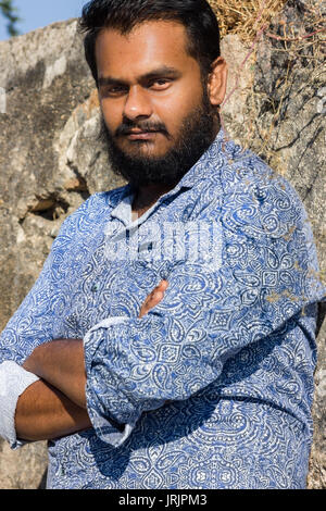 A bearded man standing with an intense look in his eyes. Stock Photo