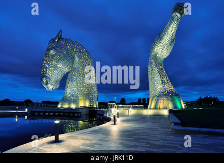 The Kelpies, 30-metre-high horse-head sculptures floodlit at night reflecting in the Forth and Clyde Canal at the Helix Parkland near Falkirk. Stock Photo