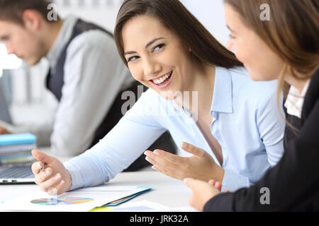 Two businesswomen talking about work at office Stock Photo