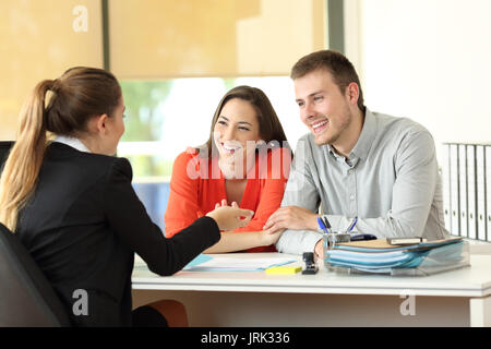Happy couple being attended by office worker at office Stock Photo