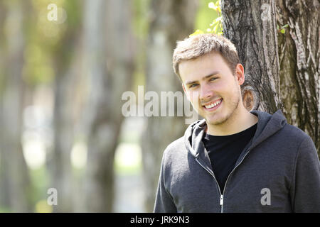 Portrait of a handsome teenager boy posing looking at you outdoors in a park Stock Photo