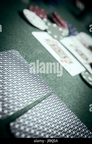 cards poker deck English, poker chips stack on green table Stock Photo