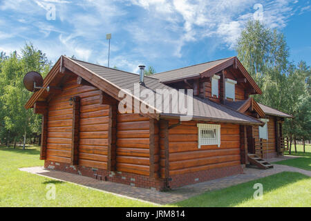 A modern wooden house made of logs. View from outside in summer Stock Photo