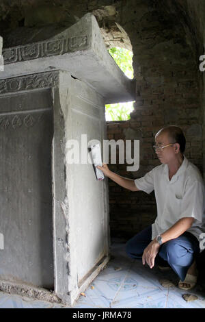 HAI DUONG, VIETNAM, September, 26: Old man reads epitaphs on September, 26, 2013 in Hai Duong, Vietnam Stock Photo