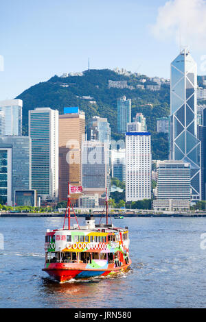 A Star Ferry approaches a ferry terminal at Tsim Sha Tsui in Hong Kong. The city's iconic Star Ferry carries passengers across Victoria Harbour betwee Stock Photo