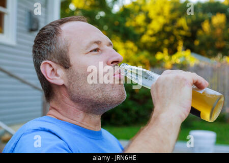 drinks, relax, leisure and people concept - close up of man drinking beer sitting on the outside Stock Photo