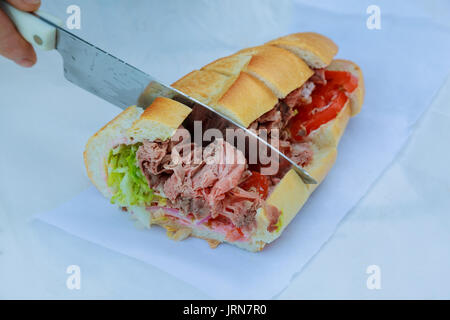 Healthy sandwich made of a fresh seeded roll, cut in half to display tasty ingredients Beef tomato, lettuce and chess, presented on a wooden board Stock Photo