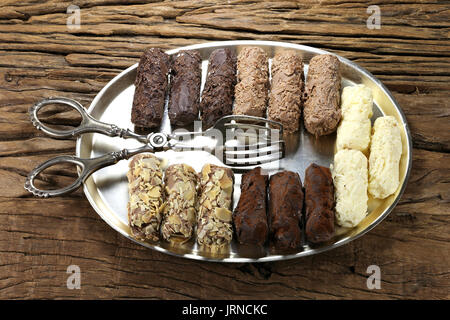 tray with handmade Belgian chocolate truffles and pastry tong on rustic wooden background Stock Photo