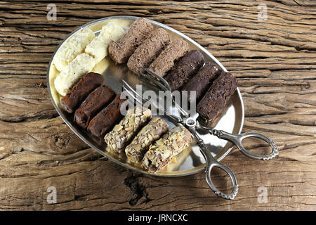 tray with handmade Belgian chocolate truffles and pastry tong on rustic wooden background Stock Photo