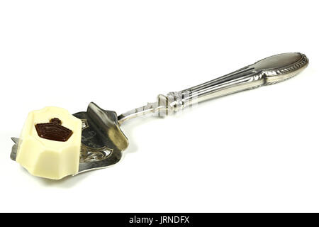 silver spoon with Belgian chocolate praline isolated on white background Stock Photo