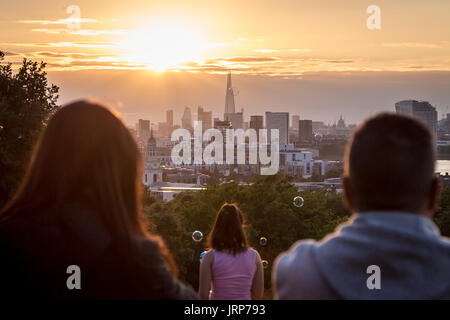 London, UK. 6th August, 2017. UK Weather: Locals and tourists enjoy the evening sunset over the city seen from Greenwich Park. © Guy Corbishley/Alamy Live News