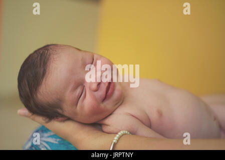 Smiling new born baby sleep in parent hands Stock Photo
