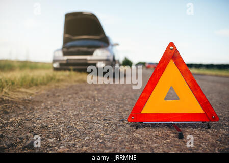 Broken car concept, breakdown triangle on asphalt road. Problem with vehicle, warning sign Stock Photo