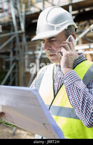 Architect On Building Site Using Mobile Phone Stock Photo