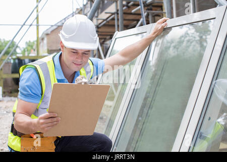Construction Worker Preparing To Fit New Windows Stock Photo