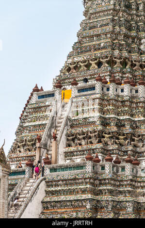 Visitors climbing the cental prang (tower) at the Wat Arun temple, on the Chao Phraya River. Yai district, Bangkok, Thailand Stock Photo