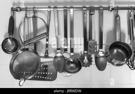 Various kitchen utensils hanging from a rack