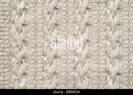 Pigtails on Beige Knitwear Fabric Texture. Machine Knitting Texture Macro Snapshot. Beige Knitted Background. Stock Photo
