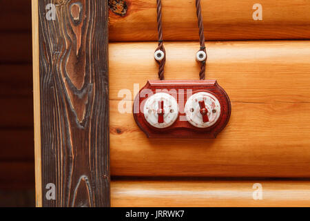 Old fashioned electricity switchs, electric wire on a wooden wall. Stock Photo