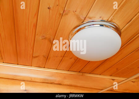Ceiling glass white lamp on a wooden ceiling Stock Photo